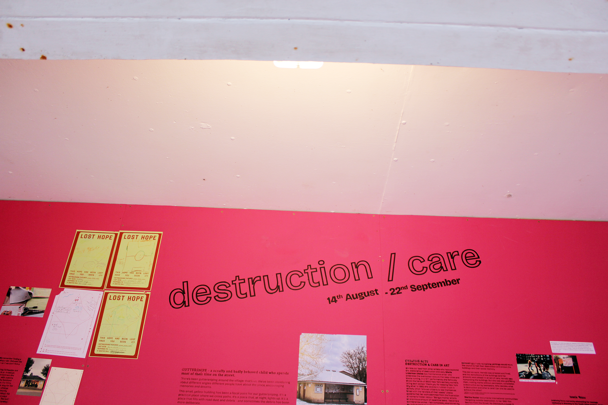 white ceiling meets pink wall with the title 'destruction/care' screenprinted in black